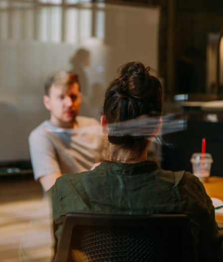 Man and woman talking to each other in a conference room