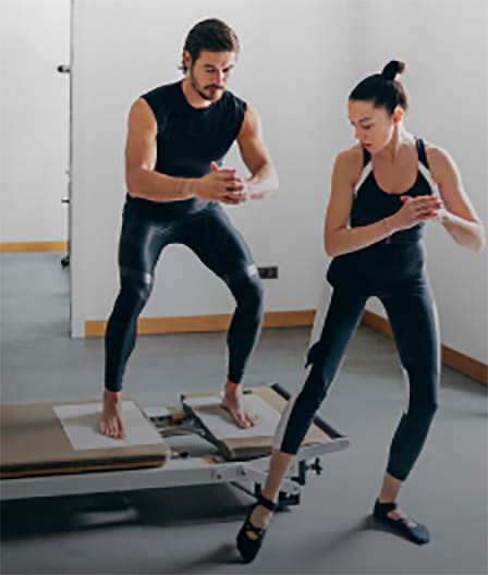 Woman instructor teaching pilates to man