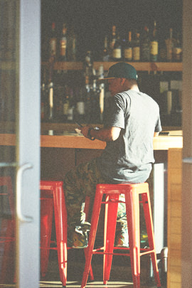 Man sitting on a red stool eating